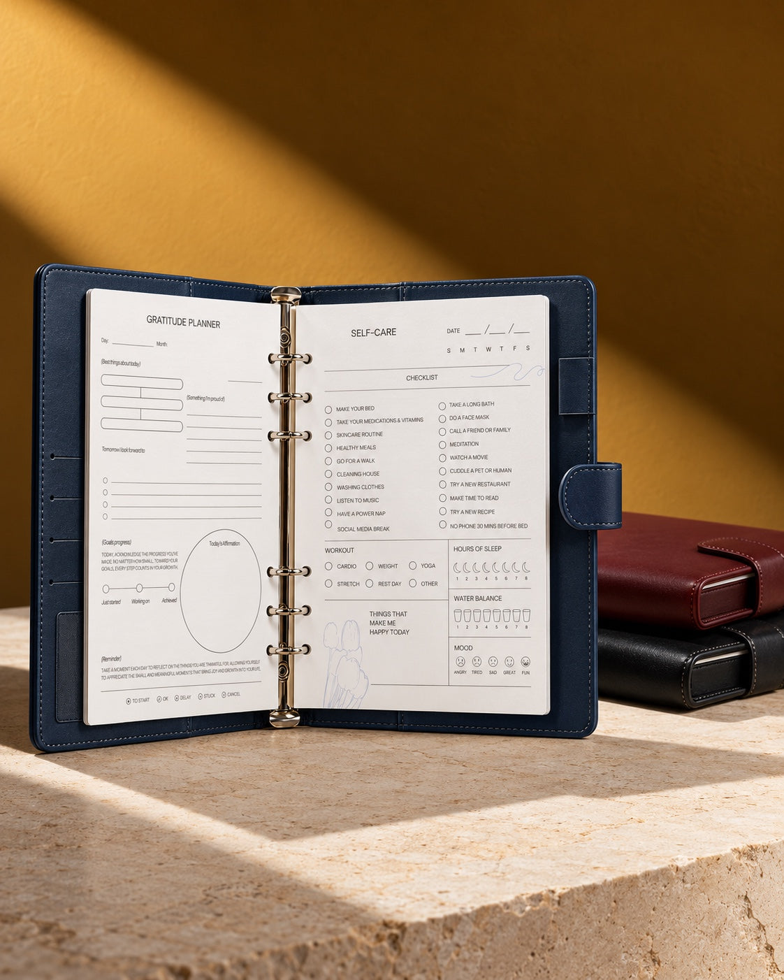 An open ring-bound Infinote planner on a stone slab with two closed planners behind it