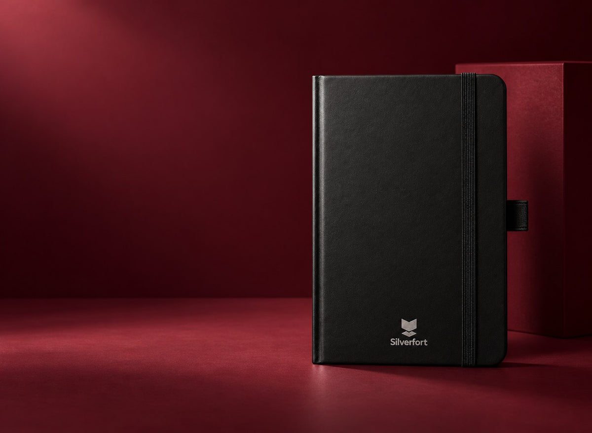 Black Infinote notebook with Silverfort identity on a deep burgundy set